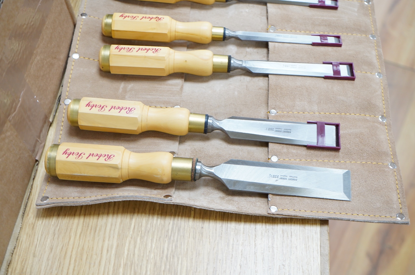 Two sets of Robert Sorby woodworking chisels, both in Kuny’s of Canada leather tool rolls; a nine piece set with octagonal handles, together with a six piece set with rosewood handles